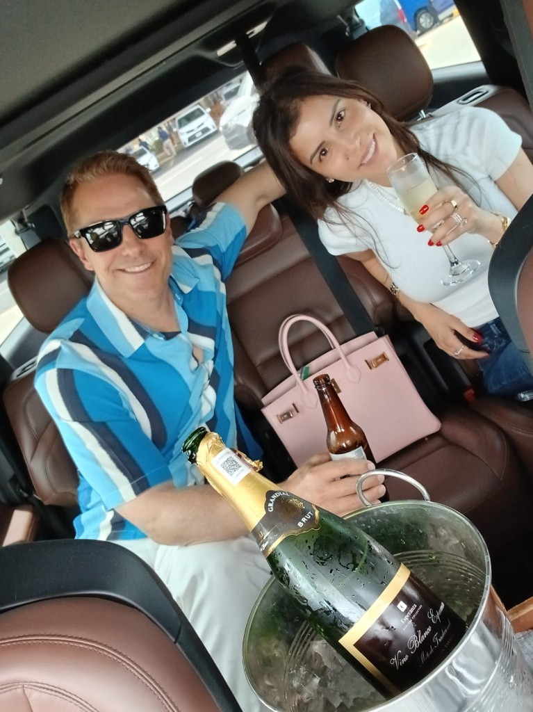 Couple toasting with champagne in a luxury private Cabo airport transportation SUV