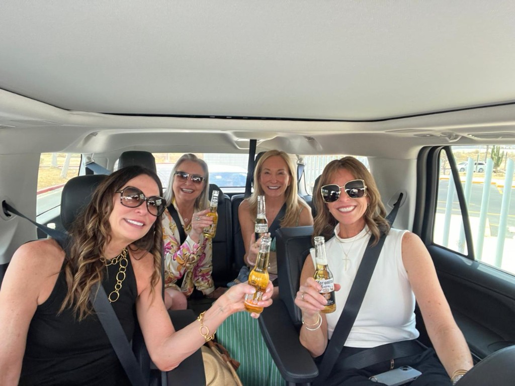 Group of friends with cold drinks on a private Cabo San Lucas shuttle service ride